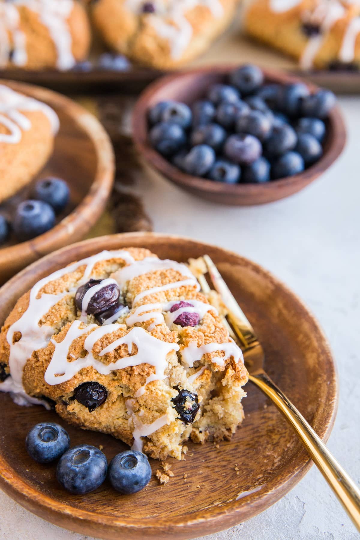 Two wooden plates with scones on them with a bite taken out of one of them