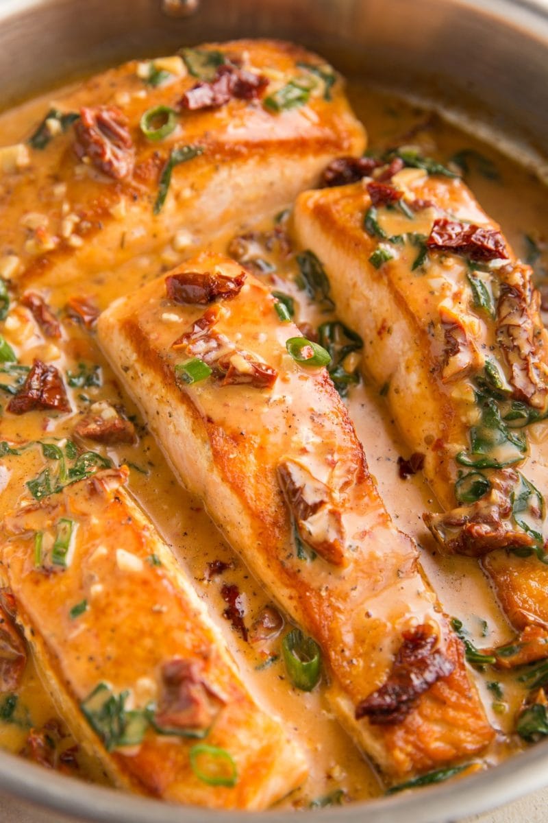 close up image of Tuscan salmon in a stainless steel skillet.