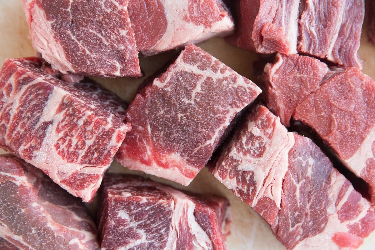 Chunks of beef sitting on a cutting board