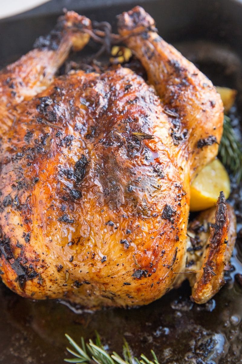 Garlic Herb Roast Chicken fresh out of the oven in a black roasting pan.