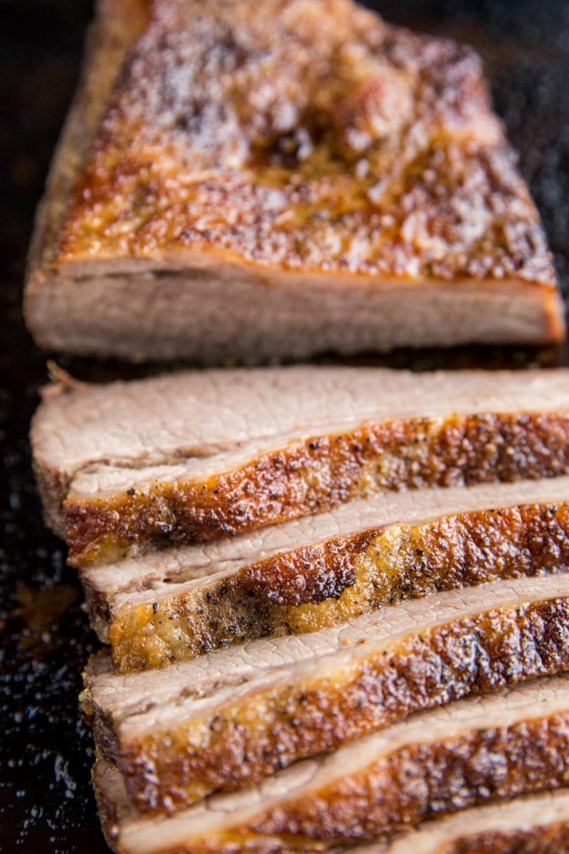 Close up image of sliced brisket on a baking sheet.