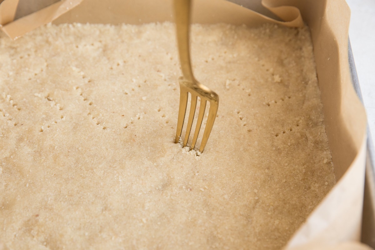 Fork poking holes in the crumb bar crust