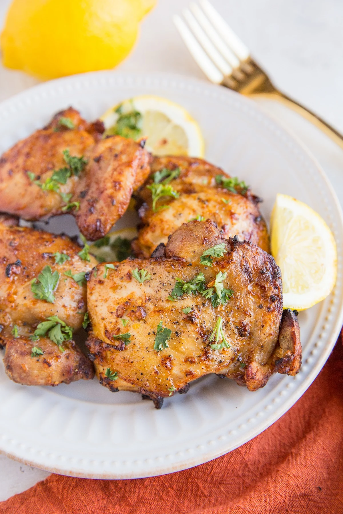 Chicken thighs on a white plate with a red napkin