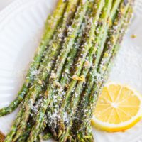 Plate of roasted asparagus sprinkled with lemon zest and parmesan