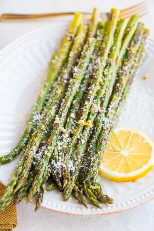 Plate of roasted asparagus sprinkled with lemon zest and parmesan