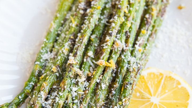 Plate of roasted asparagus sprinkled with lemon zest and parmesan