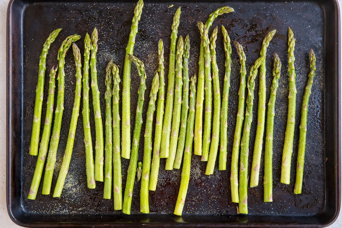 asparagus spread over a baking sheet.