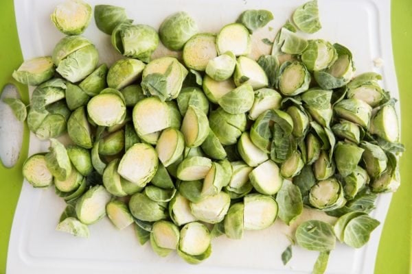 Brussels sprouts cut in half on a cutting board