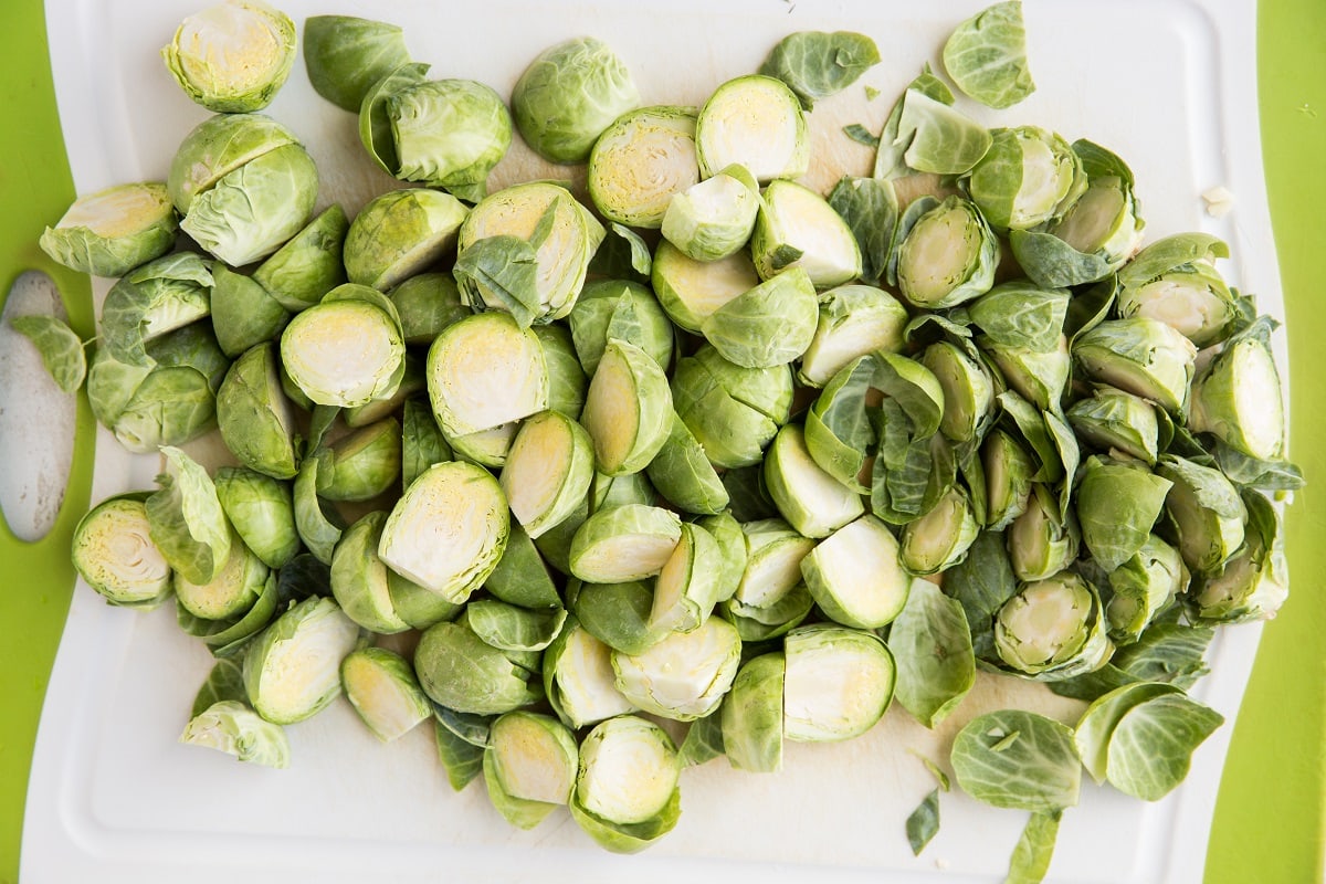Brussels sprouts cut in half on a cutting board