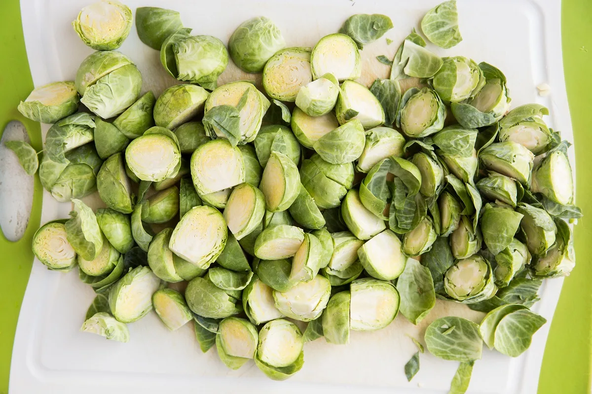 Brussels sprouts cut in half on a cutting board