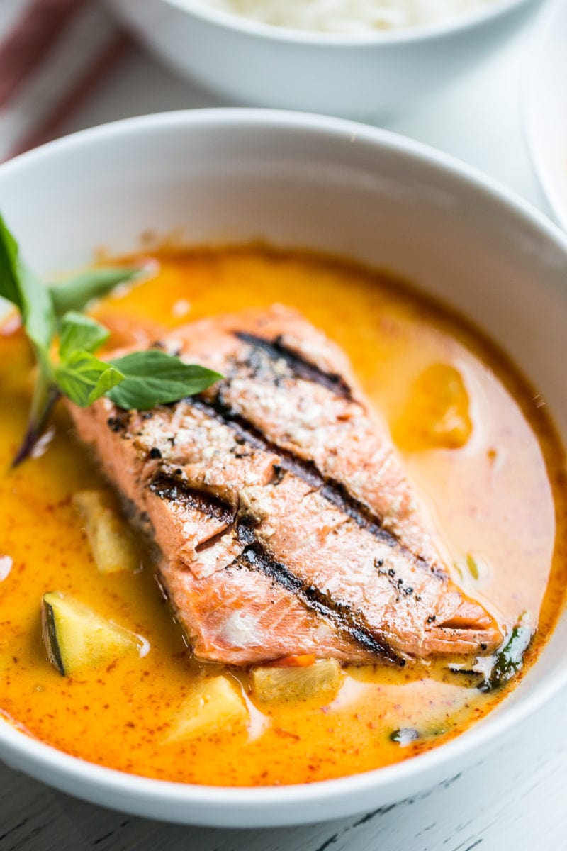Grilled salmon in a bowl surrounded by curry sauce