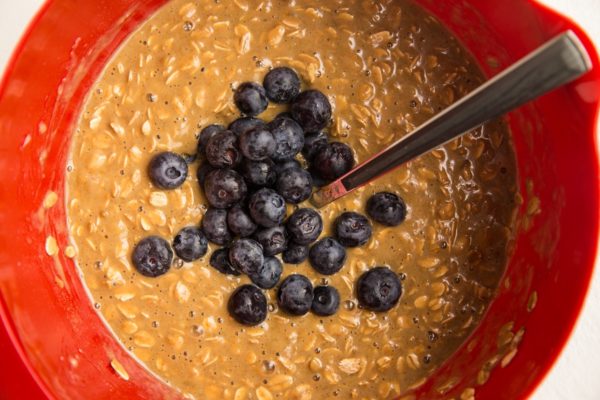 blueberries on top of oat mixture in a mixing bowl