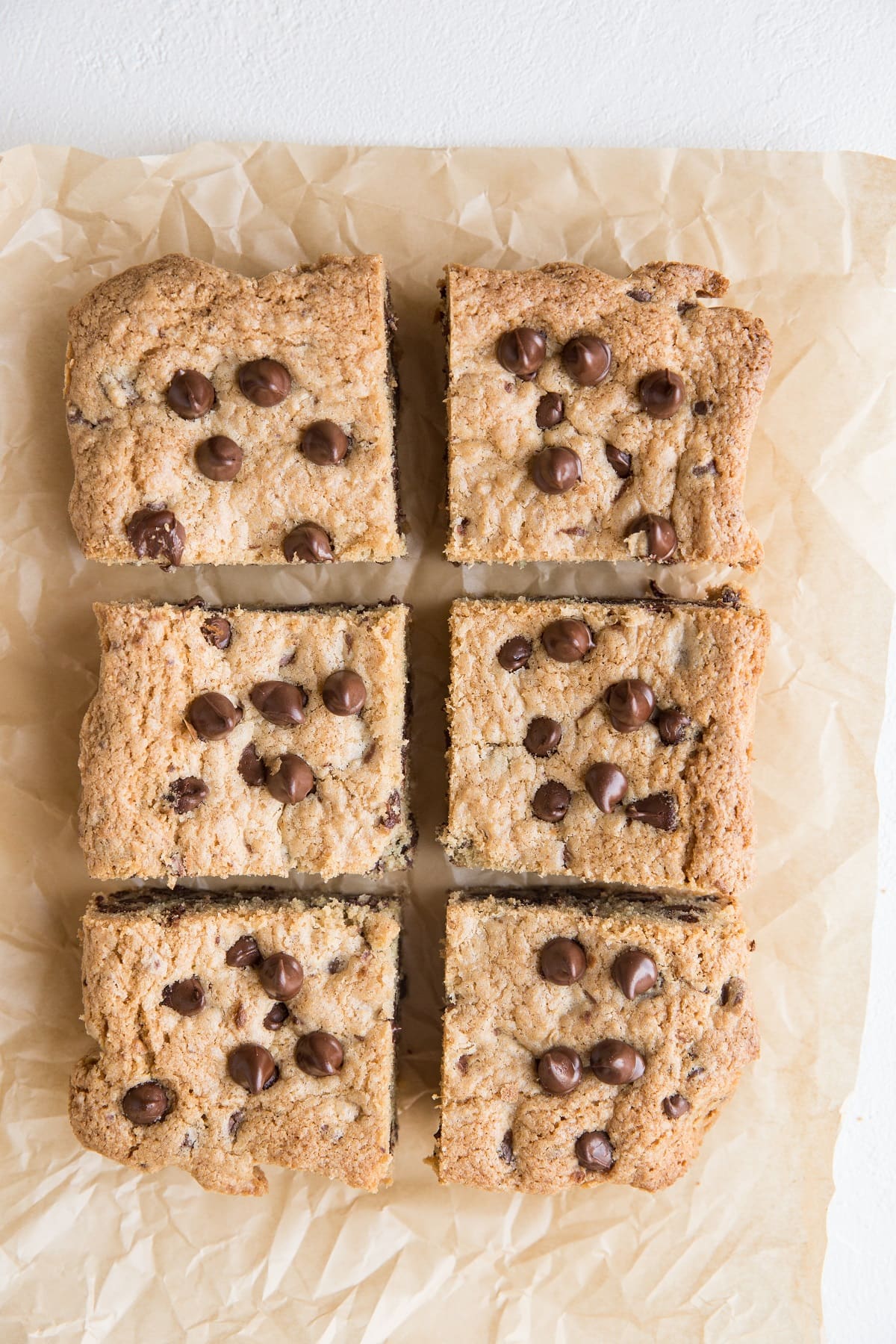 Cookie bars sliced into individual portions on a parchment paper