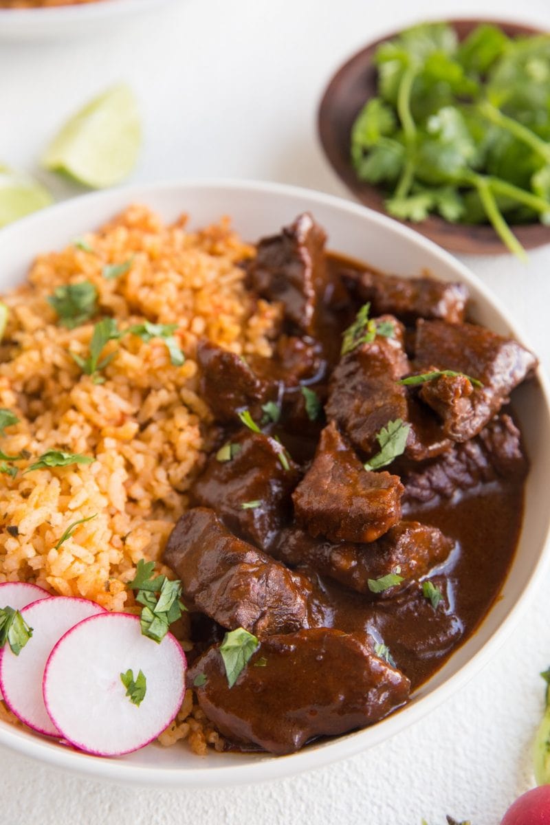 Bowl of chile colorado with a side of Spanish rice