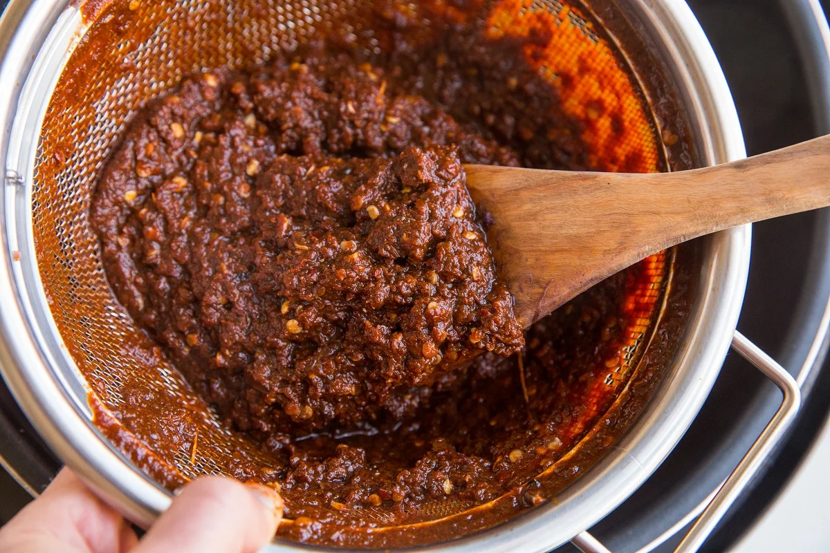 Chile pulp in a strainer from red chile sauce