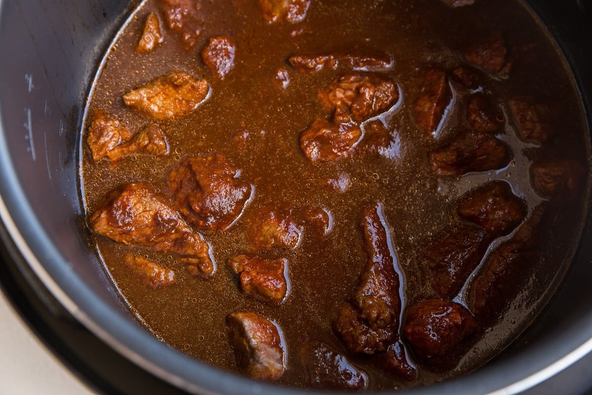 Beef and red chile sauce in an instant pot, ready to pressure cook