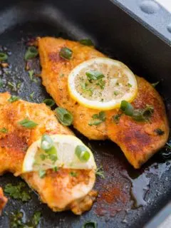 Lemon garlic chicken breasts in a black roasting pan
