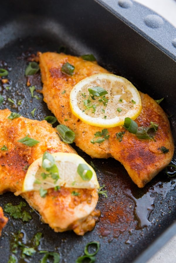 Lemon garlic chicken breasts in a black roasting pan