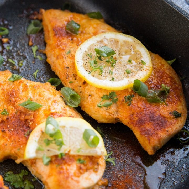 Lemon garlic chicken breasts in a black roasting pan