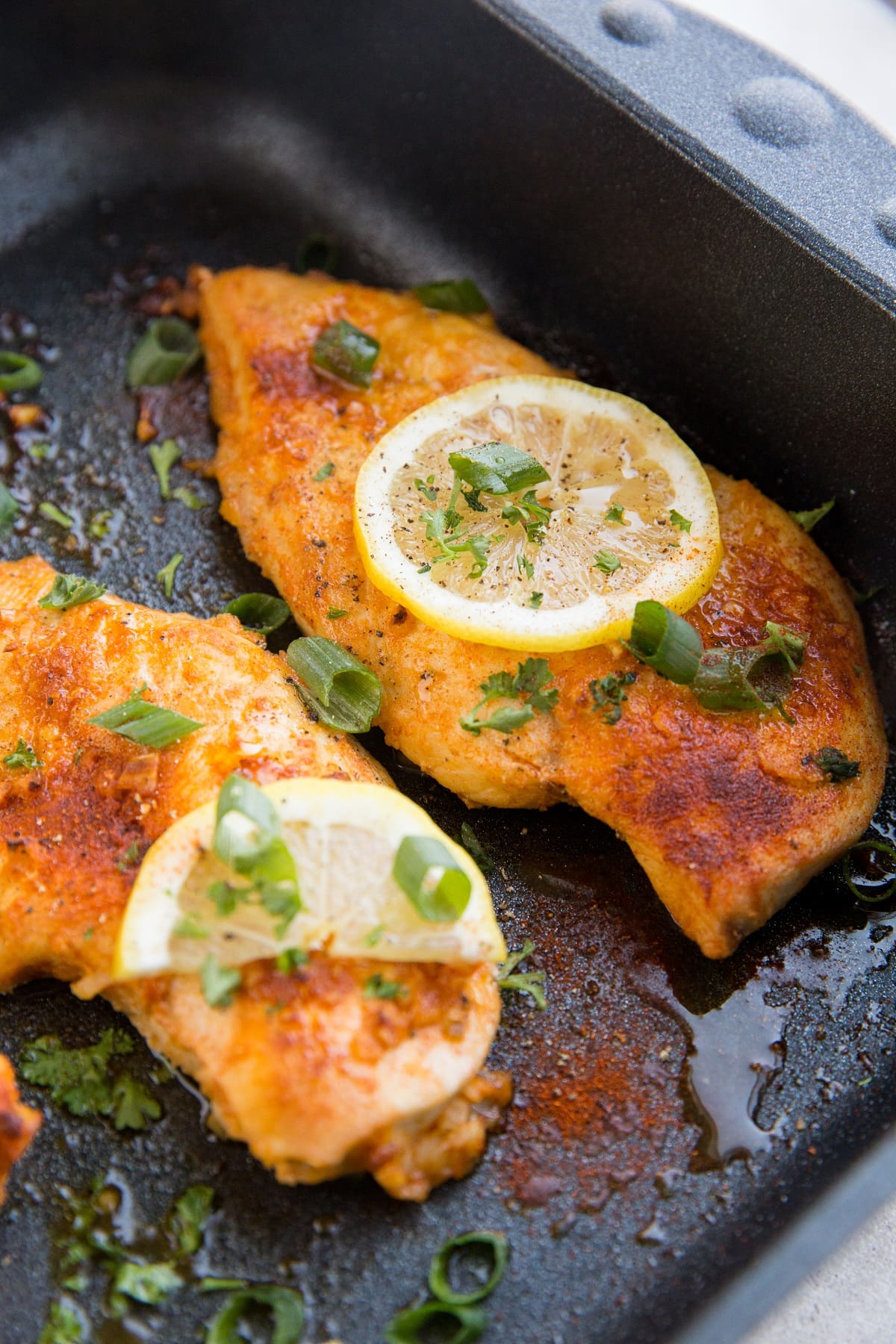 Lemon garlic chicken breasts in a black roasting pan