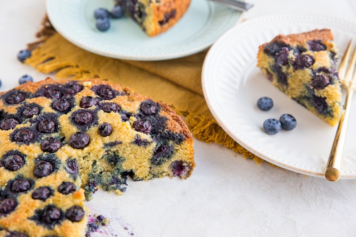 Blueberry cake with two slices cut out on plates