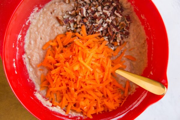 grated carrots and chopped pecans on top of muffin batter.