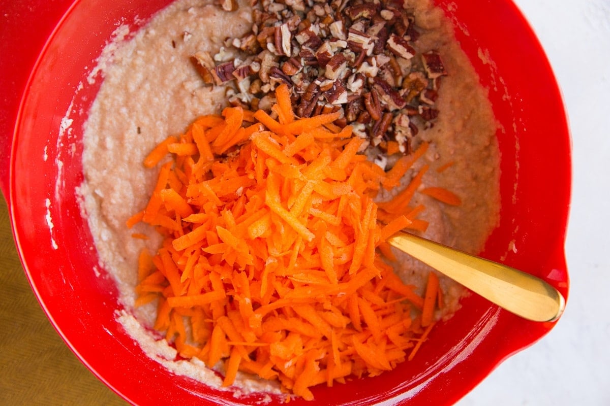 grated carrots and chopped pecans on top of muffin batter.