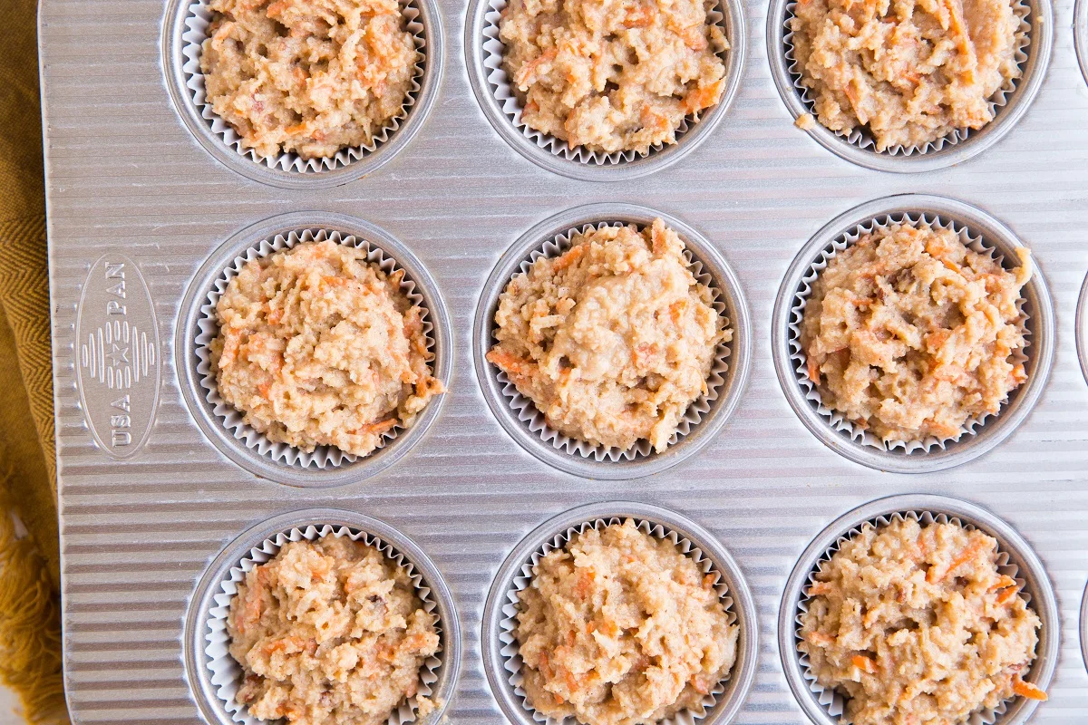 Muffin tray with muffin batter in the holes