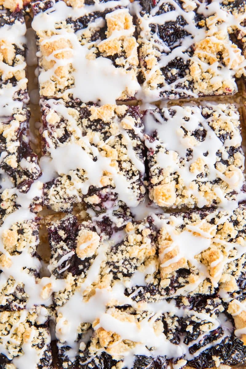 top down photo of cherry pie bars cut into squares with glaze drizzled on top.