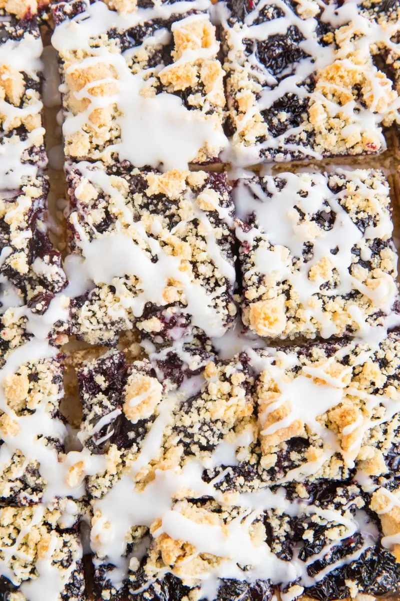 top down photo of cherry pie bars cut into squares with glaze drizzled on top.