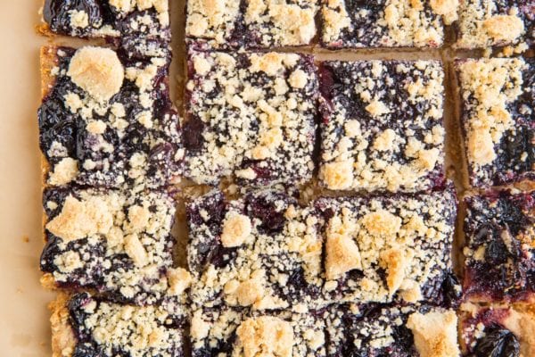 Finished cherry pie bars on parchment paper, cut into squares