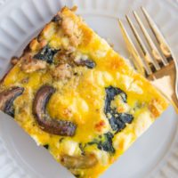 close up top down photo of mushroom and sausage breakfast casserole on a white plate