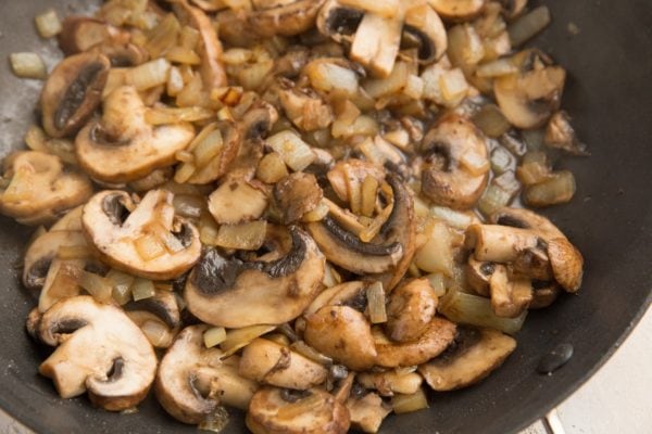 mushrooms and onions cooking in a skillet