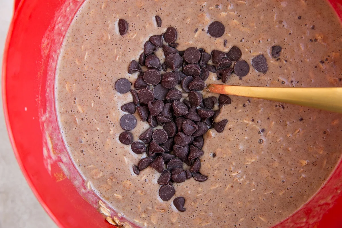Chocolate chips in a mixing bowl with baked oatmeal ingredients