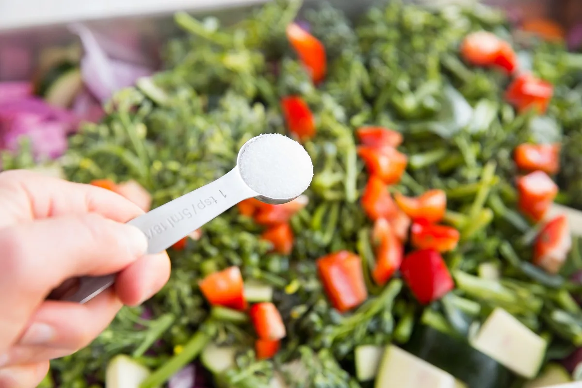 Sprinkling salt over the veggies