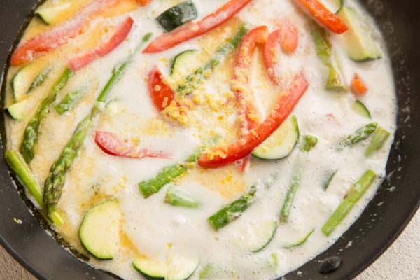 Vegetables in a skillet with a creamy lemon sauce surrounding them