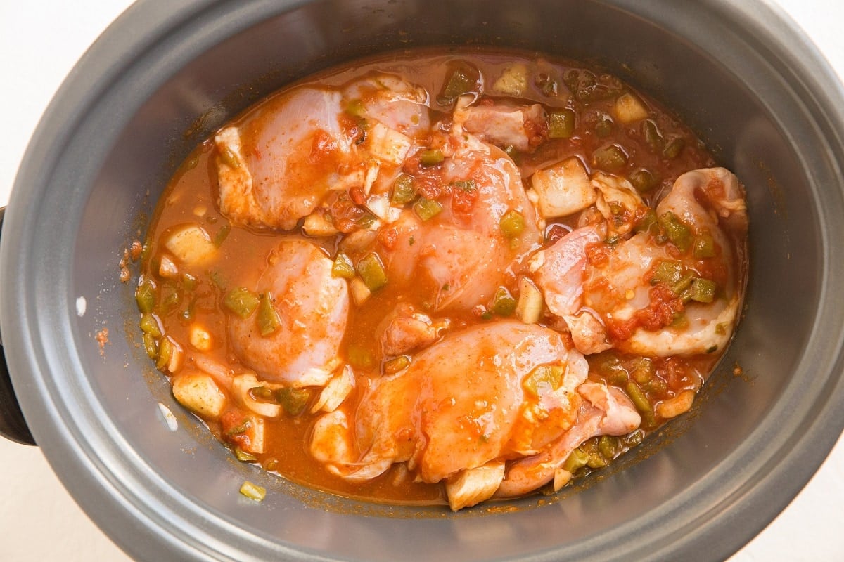Raw ingredients for shredded chicken stirred together in a crock pot