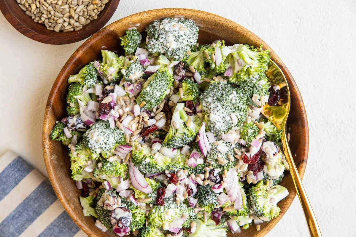 horizontal photo of a wooden bowl of classic broccoli salad