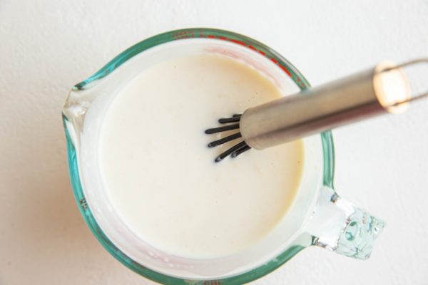 creamy broccoli salad dressing in a measuring cup.