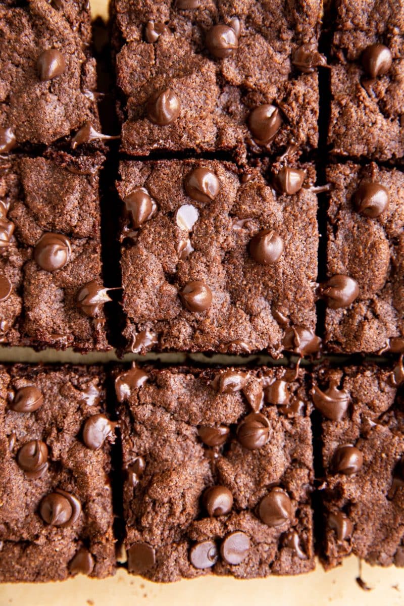 Batch of grain-free brownies sliced on a piece of parchment paper.