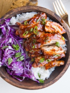 Bowl of Hawaiian BBQ Chicken on top of white rice with red cabbage to the side.