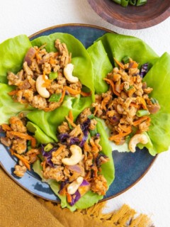 blue plate of Thai ground turkey lettuce wraps with golden napkin to the side.