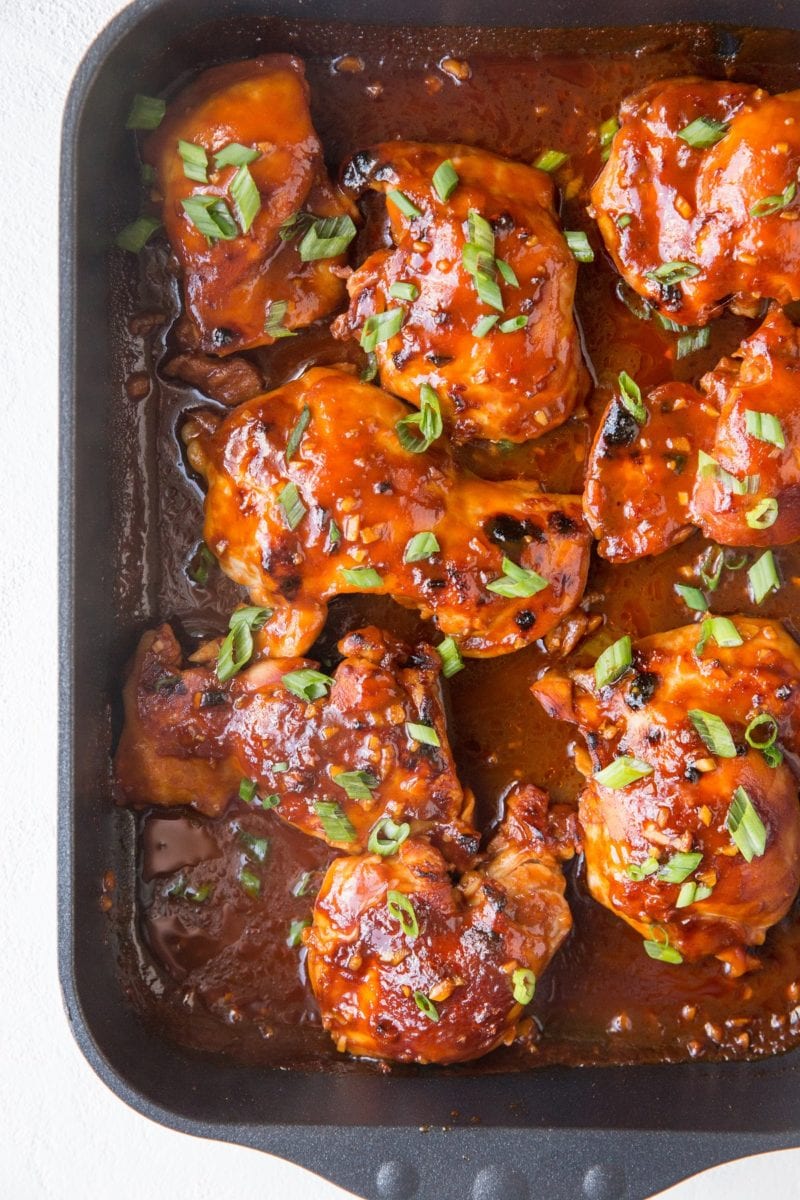 Casserole dish with BBQ chicken all sauced up with green onions sprinkled on top