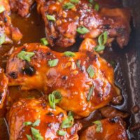 Casserole dish of Hawaiian BBQ Baked Chicken with sauce and green onions on top.