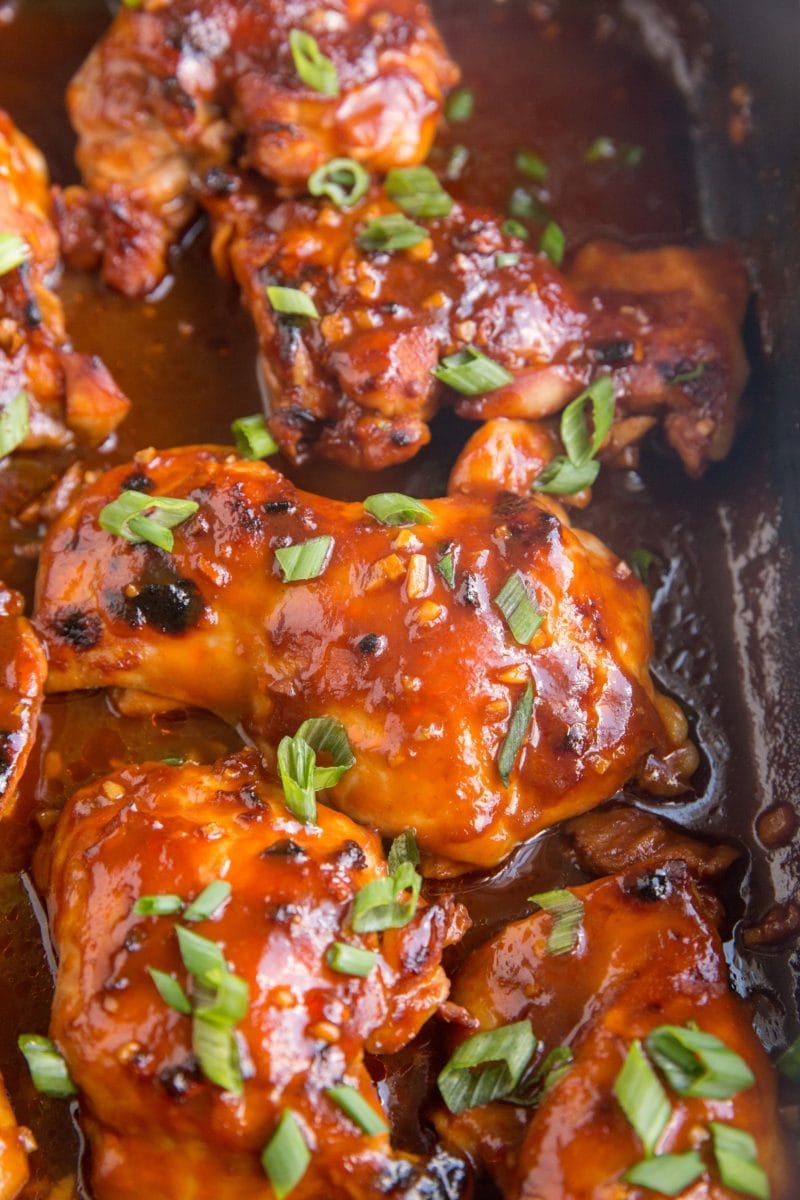 Casserole dish of Hawaiian BBQ Baked Chicken with sauce and green onions on top.