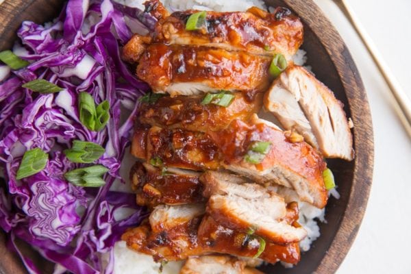 Wooden bowl with white rice, Hawaiian chicken, and cabbage slaw.