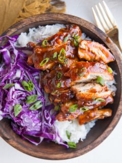 Bowl of Hawaiian BBQ Chicken on top of white rice with red cabbage to the side.