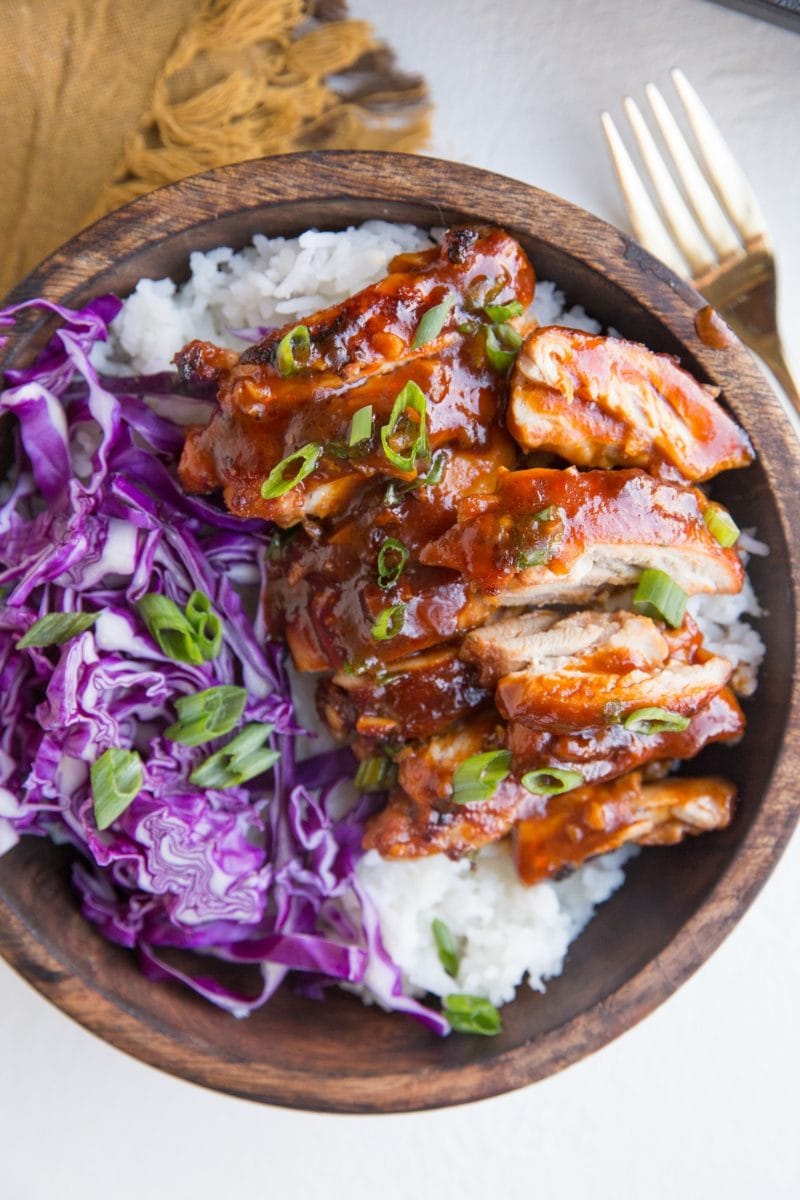 Bowl of Hawaiian BBQ Chicken on top of white rice with red cabbage to the side.