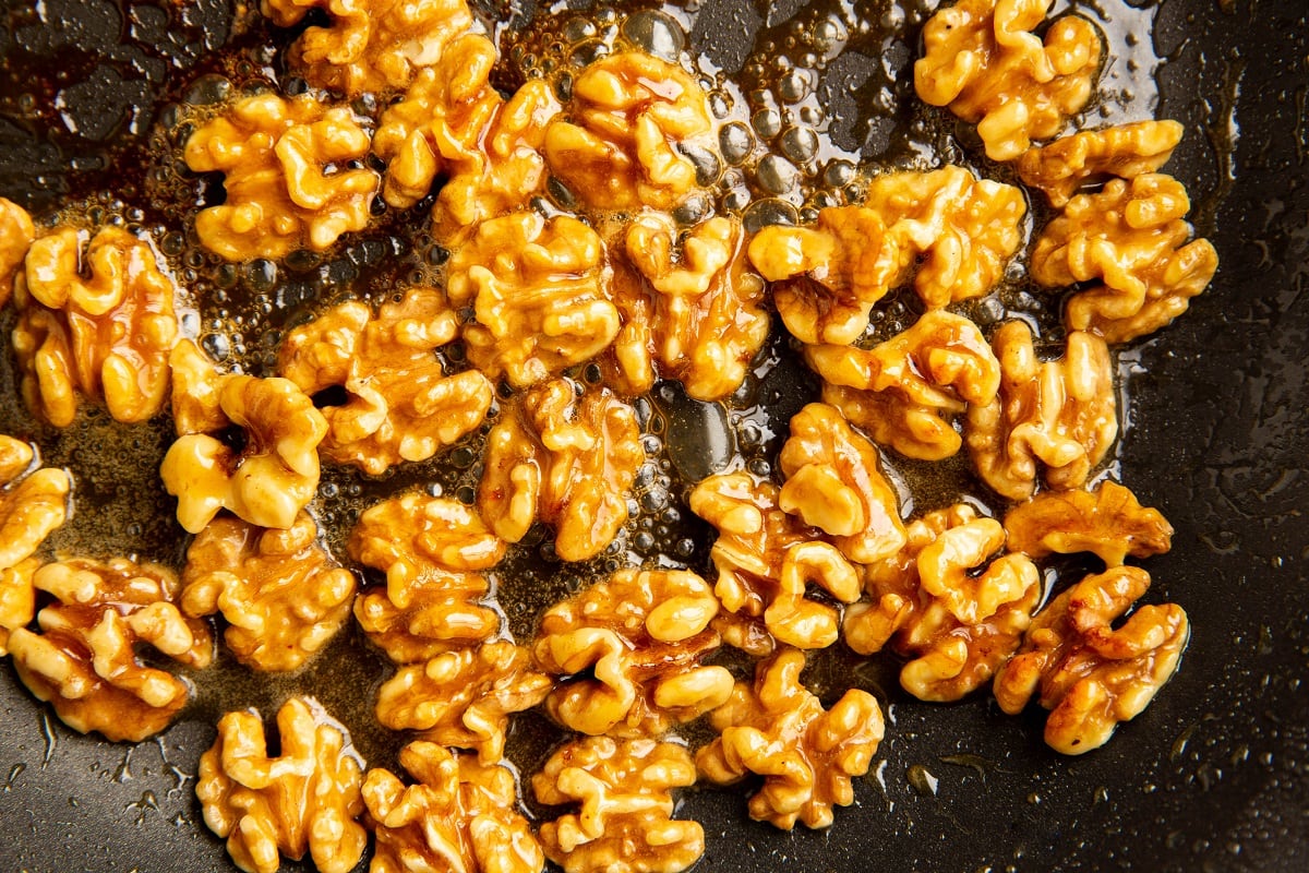 Honey candied walnuts in a skillet