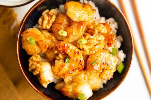 horizontal photo of healthy honey walnut shrimp in a blue bowl